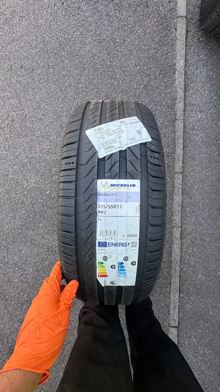 A new Michelin 225/55 R17 tyre, still labelled, about to be fitted